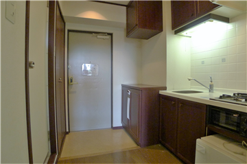 和室側よりキッチン(約1.9畳)と玄関ホールを撮影