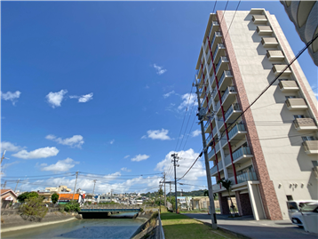 川沿いに建つ地上１１階建ての外観（右手前）